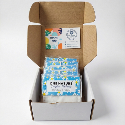 Open cardboard box containing packages labeled 'One Nature' with a business card on top.