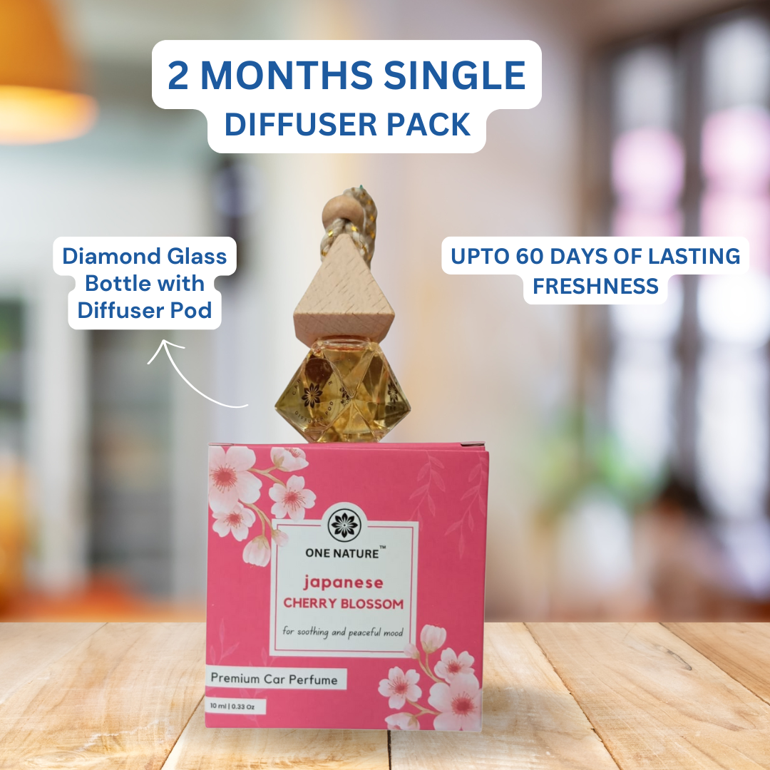 One Nature Japanese Cherry Blossom car perfume with diamond glass bottle and diffuser pod on a wooden surface.