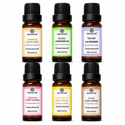 Six amber glass essential oil bottles arranged in two rows of three on a plain white background. Each bottle has a black cap and a different colored label: orange, green, lavender, pink, yellow, and brown.