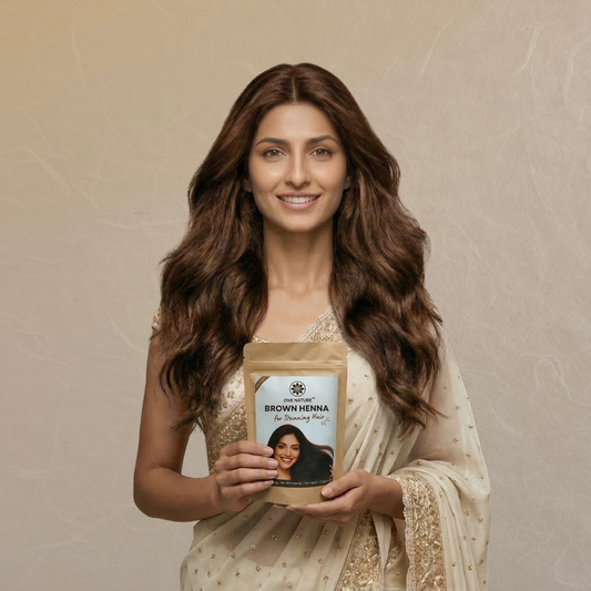 Woman holding a package of brown henna for hair against a beige background
