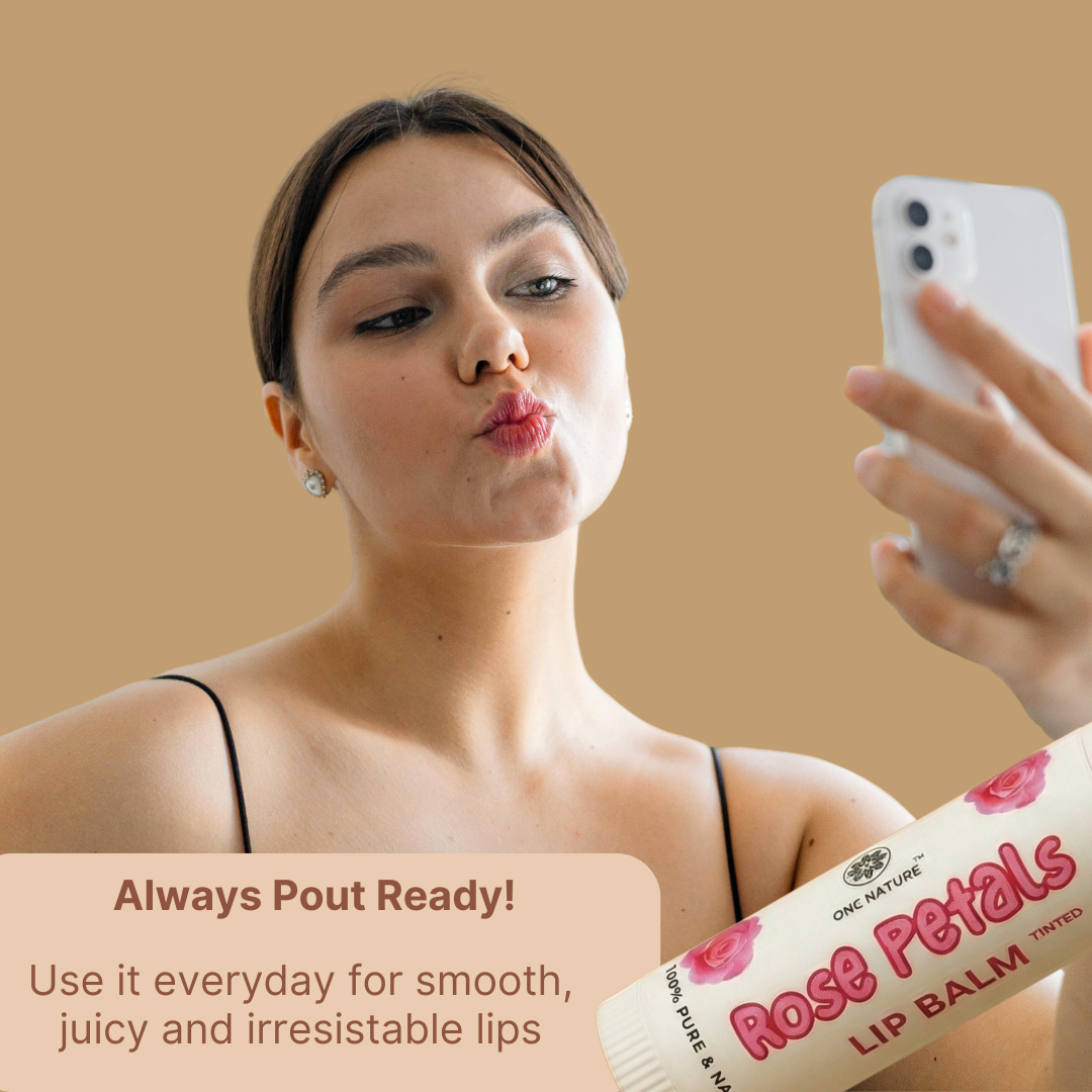 Woman applying lip balm and taking a selfie with a phone, with a product label visible.