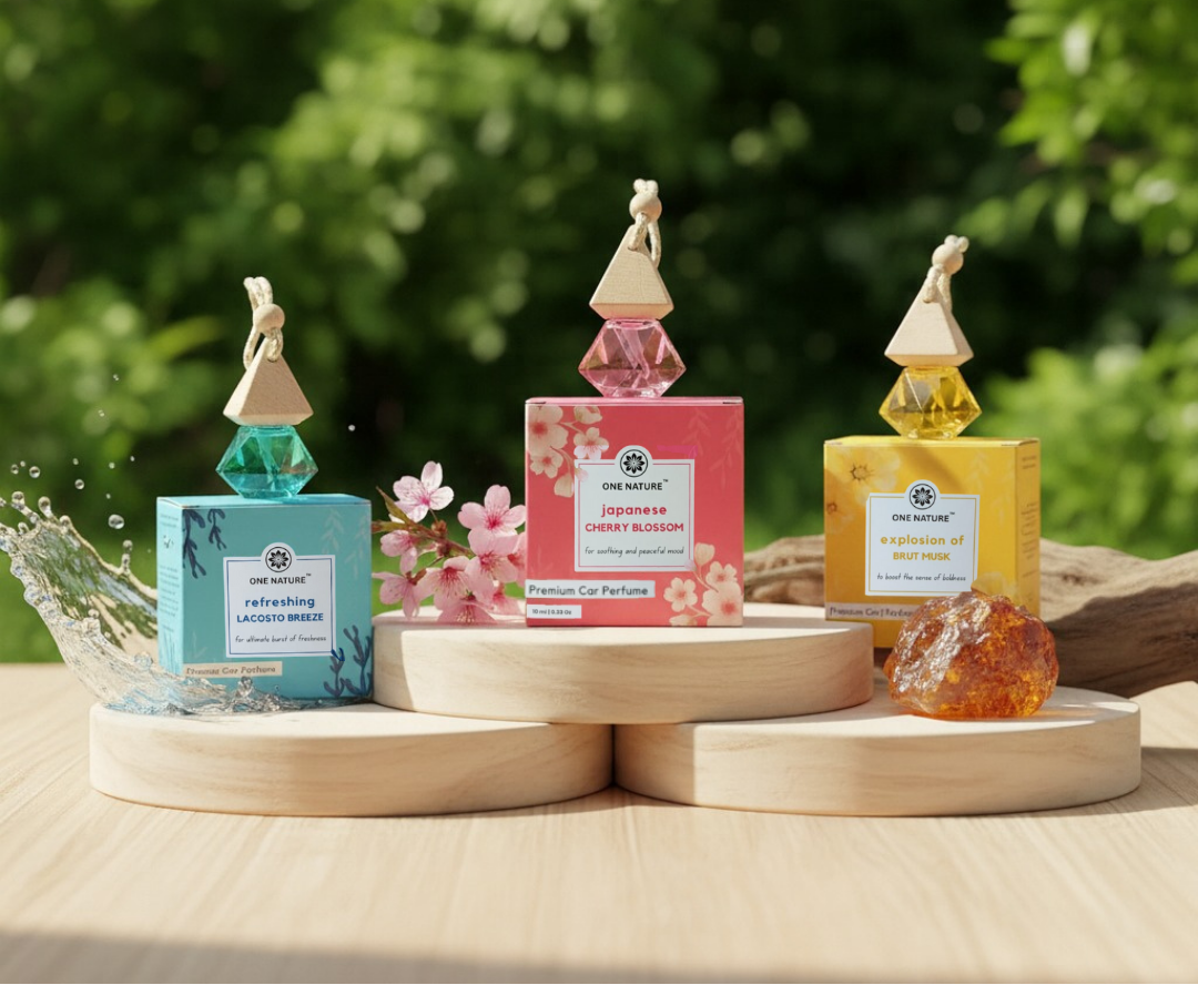 Three car air fresheners on wooden stands with a green outdoor background